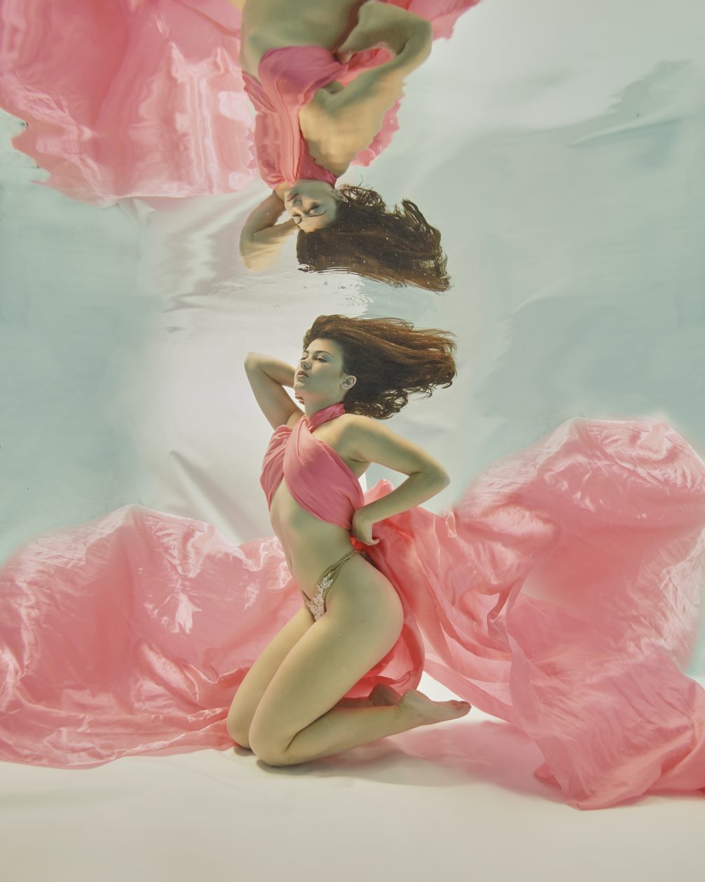 Underwater model wrapped in pink satin