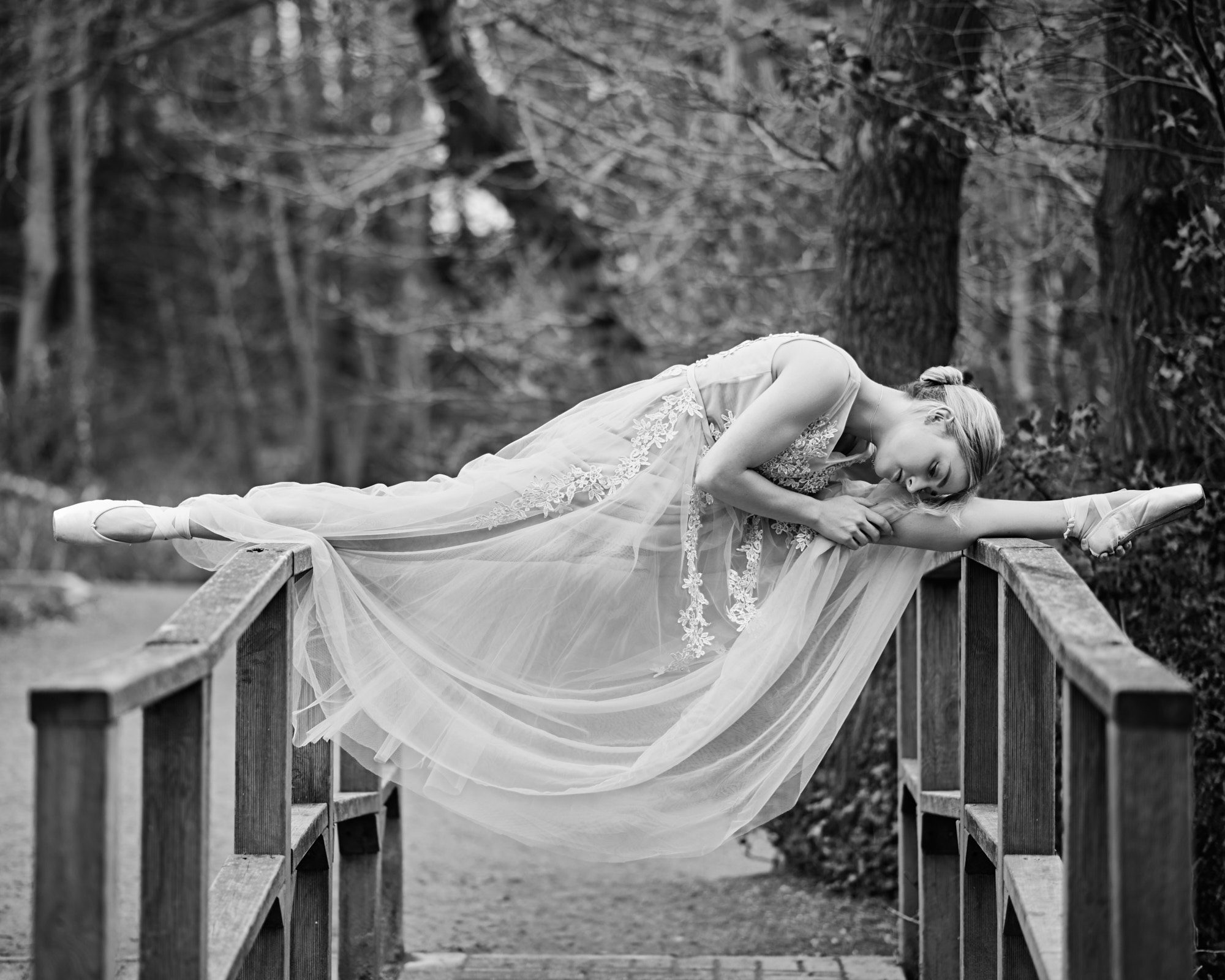 Ballet dancer doing the splits on a bridge