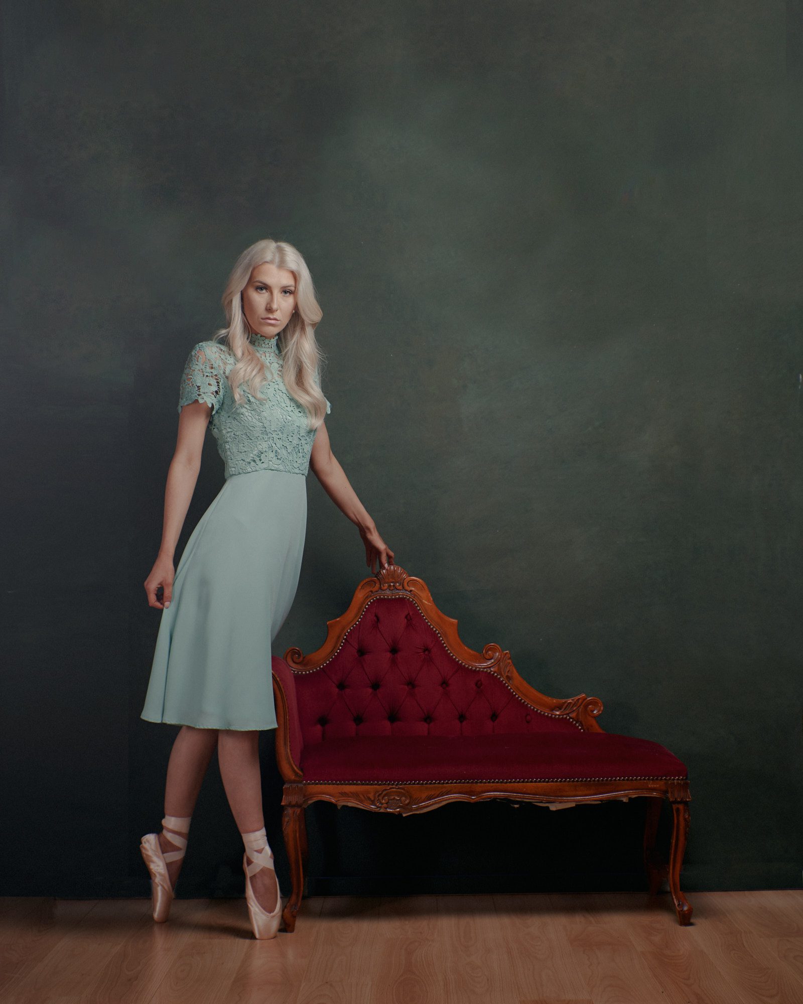 Surrey girl in a green dress next to a red Chaise Lounge