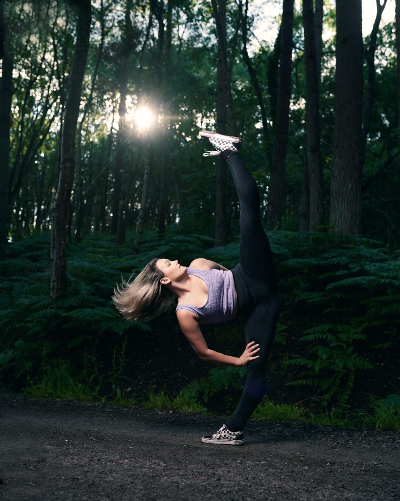 Phoebe Marsh Surrey dancer in the woods executing a high kick