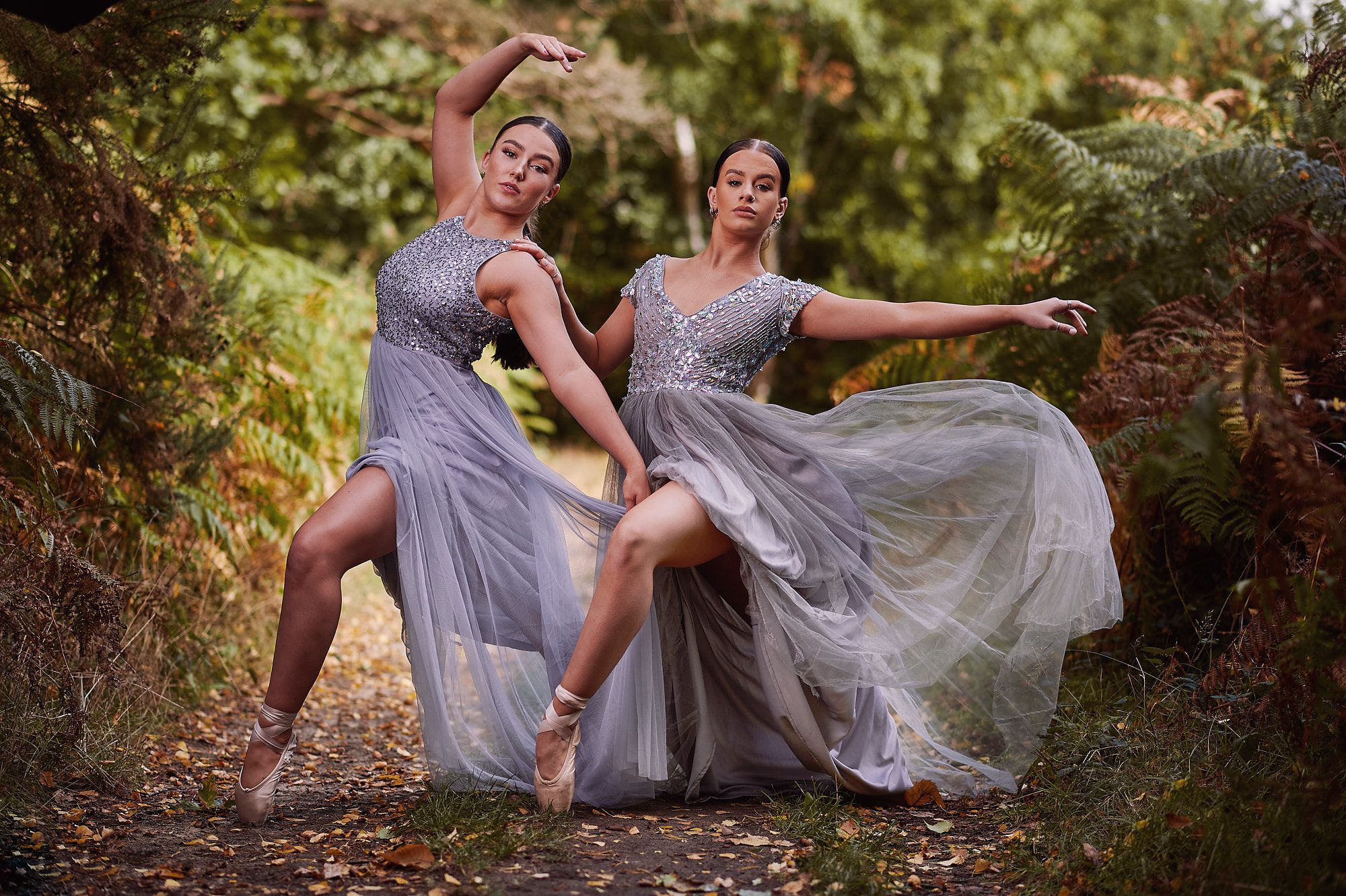 Two dancers posing in grey flowing dresses