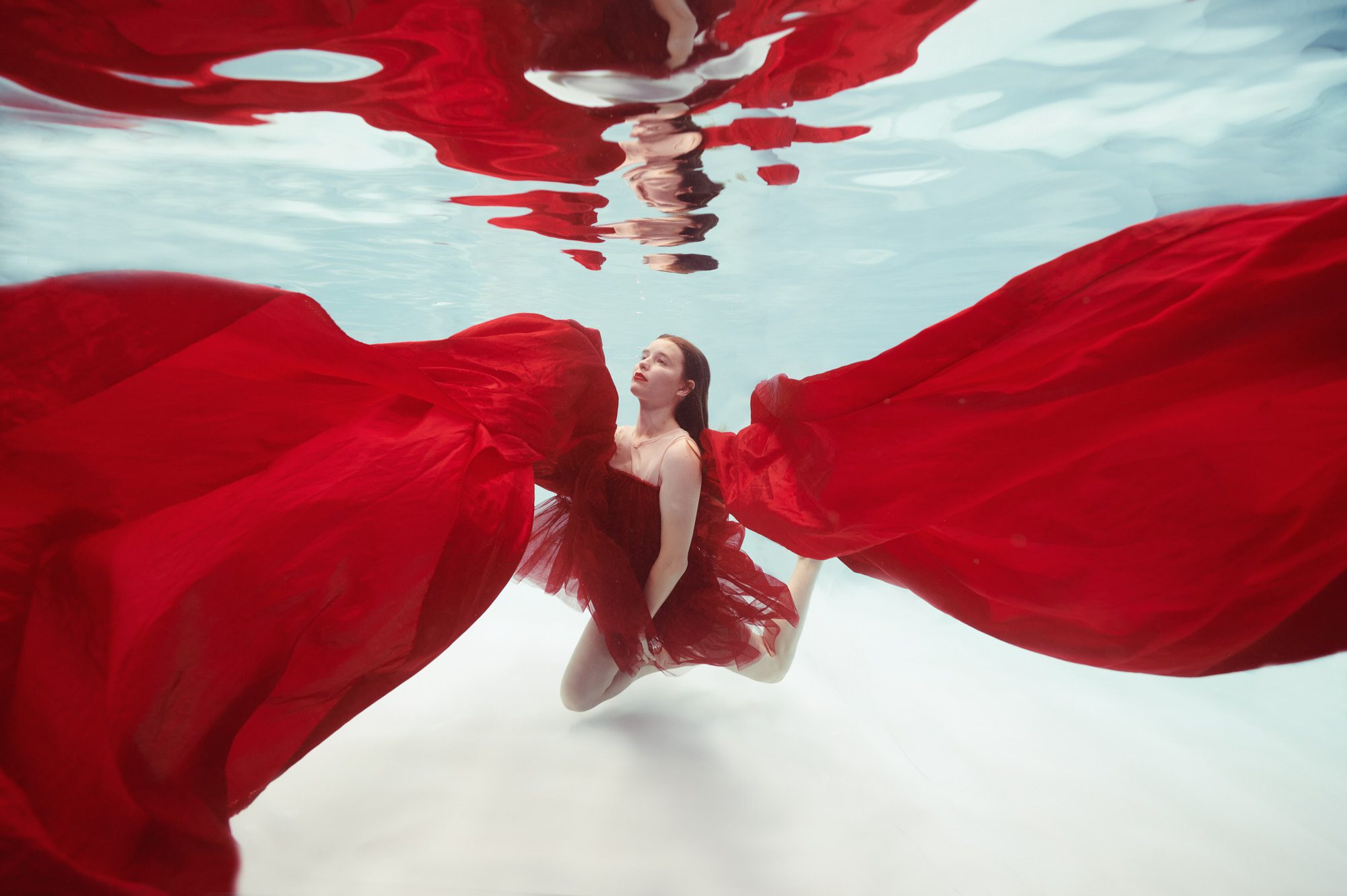 Model floating underwater in Red fabric